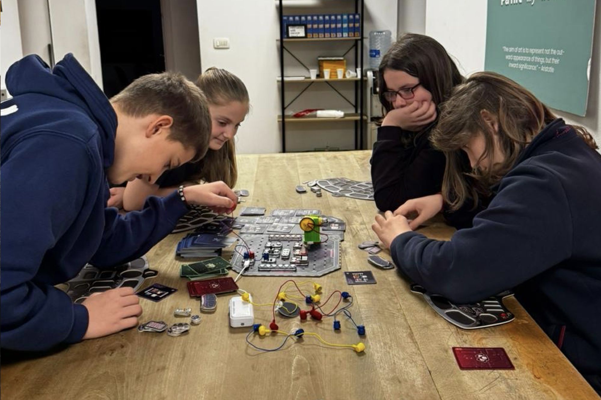 Teens leaning in, building circuits together